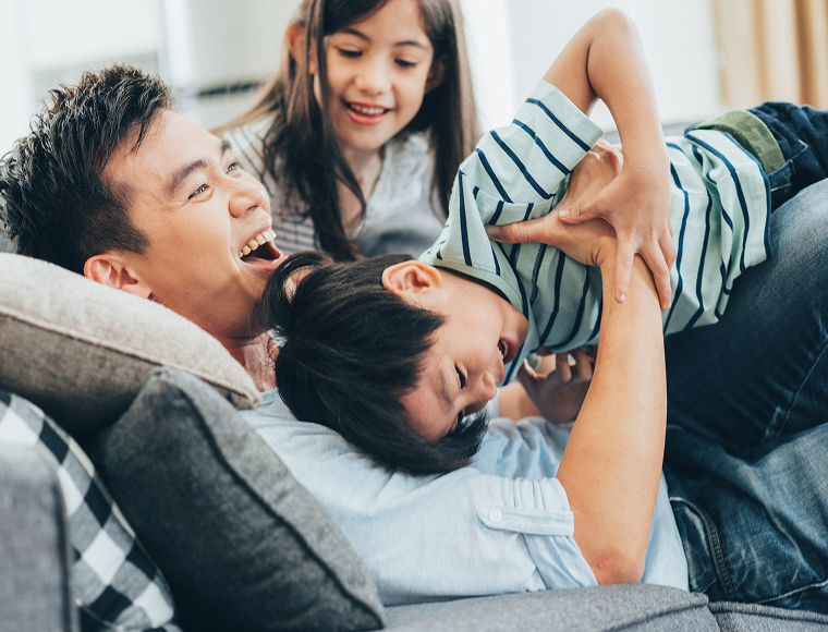 young kids wrestling with father