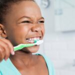 young girl brushing her teeth, how to motivate kids to brush teeth