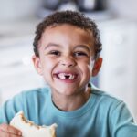 young boy with missing baby teeth, swallowed baby tooth