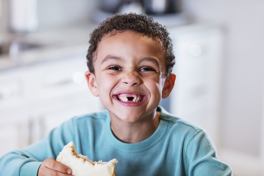 young boy with missing baby teeth, swallowed baby tooth