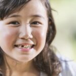 girl with loose tooth, missing teeth