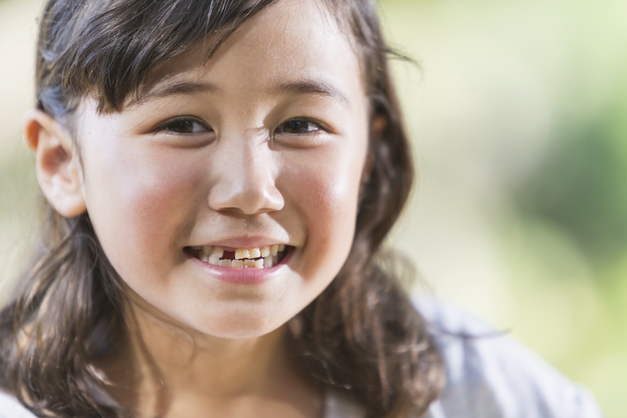girl with loose tooth, missing teeth